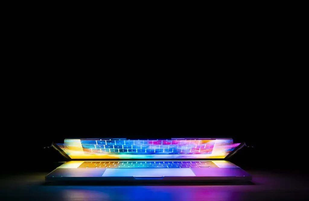 Nowoczesny laptop z podświetlaną klawiaturą, symbolizujący zaawansowaną technologię i wydajną pracę.